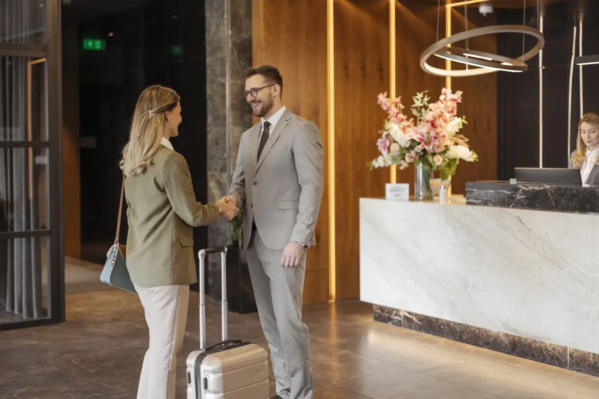 Traveller with luggage being welcomed at a hotel reception